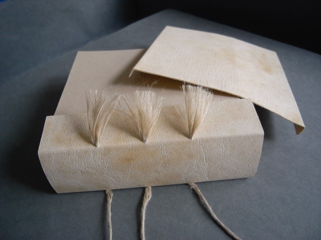 Fig 1.10 – Laced-on spine piece showing trimmed and frayed-out cords.