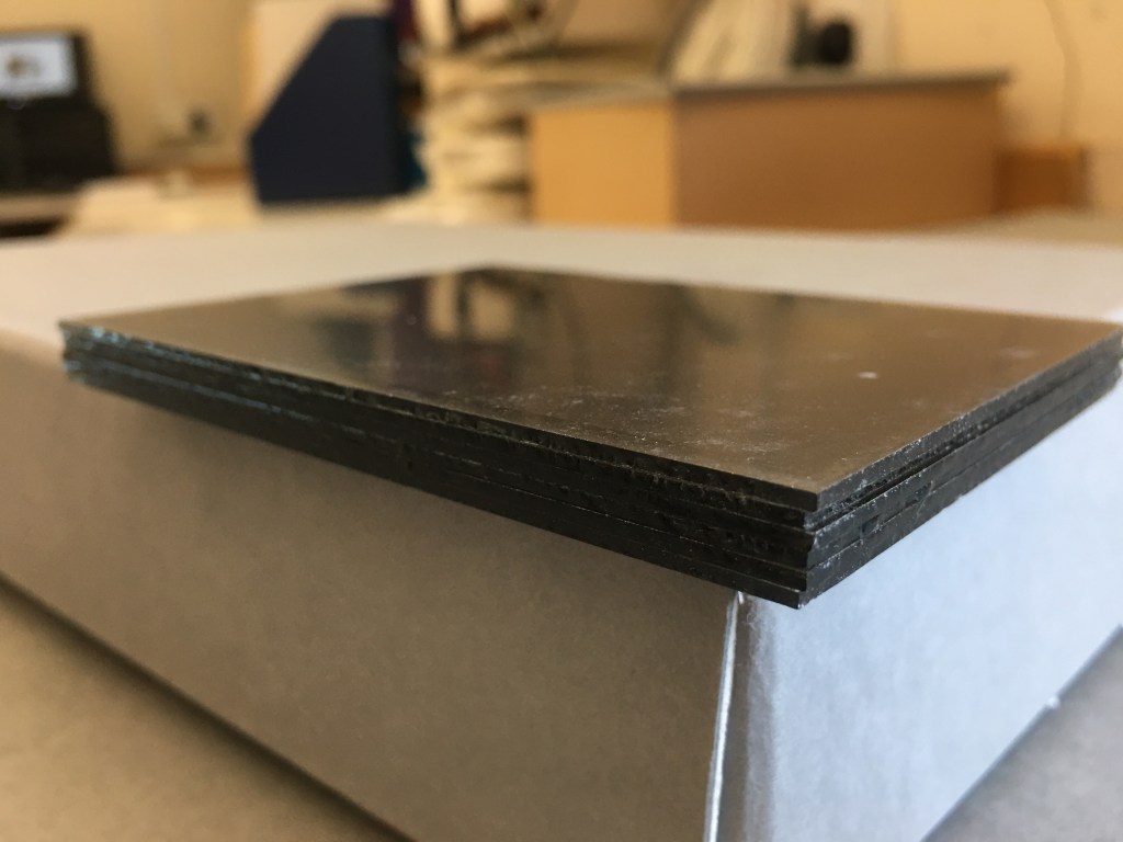 Glass negatives from the Bedfordshire Archives BT Neg collection, emulsion layers fused together due to historical water damage. Photo by Alison Faden.